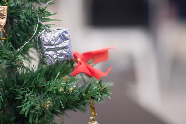 Mini gift box hanging on Christmas tree — Stock Photo, Image