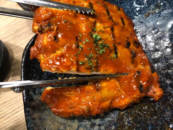 Chef memotong iga panggang dan asap dengan saus barbeque — Stok Foto