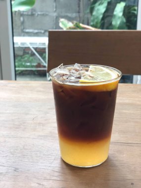 Üstünde portakal suyu ve limon dilimi olan soğuk kahve karışımı.