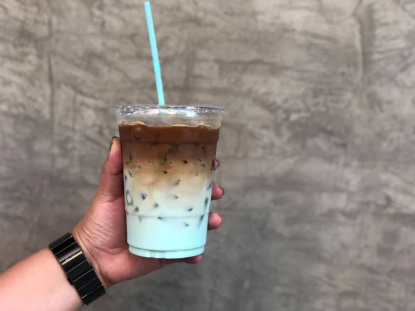 Hand woman holding a glass of iced coffee with mint syrup — ストック写真