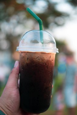 Plastik bardakta buzlu sade kahve. Oliang adında bir Taylandlı.