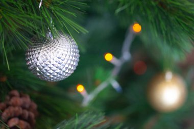 Noel ağacında asılı güzel Noel süslemelerine yakın durun. Mücevher gibi gümüş bir top.