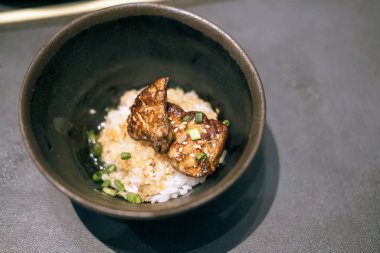 Üzerine ızgara kaz ciğeri konmuş kase pilav.