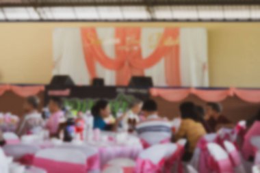 Büyük sahnenin bulanık görüntüsü ve Tayland düğününde masada oturan misafir. Arkaplan için kullan