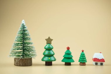 Sarı arka planda çeşitli boyutlarda Noel ağaçları.