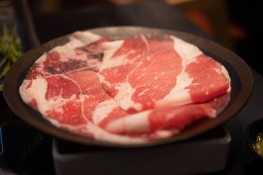 Siyah tabakta ince dilimlenmiş et.