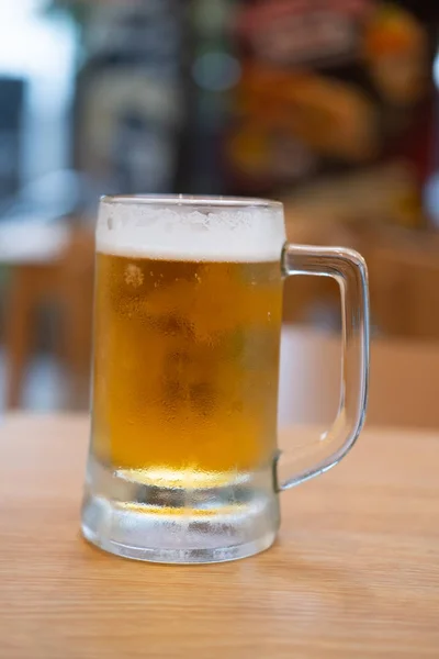 Cerveza en vidrio sobre mesa de madera — Foto de Stock