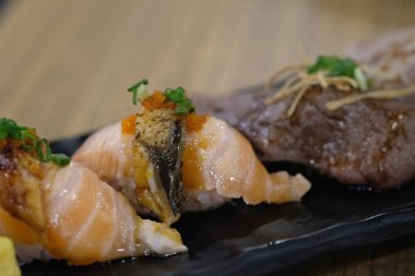 Siyah tepside servis edilen çeşitli suşiler.