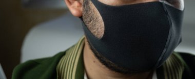 Siyah maskeli adam hava kirliliğine karşı filtre koruyor.