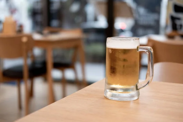 Vidro de cerveja na mesa de madeira — Fotografia de Stock