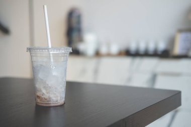 Ahşap masada buz küplü plastik cam.