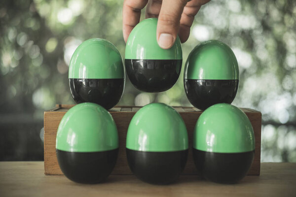 Hand randomly pick black and green plastic egg or egg surprise toys. Concept of egg surprise