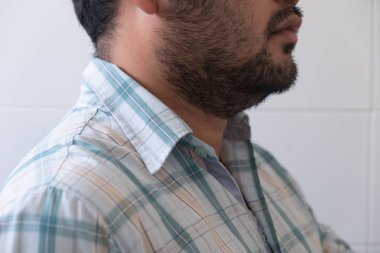 Genç sakallı adam ekose gömlek giyiyor. 