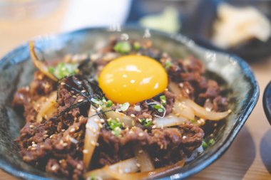 Japon usulü yemeğin soğan ve soya içerikli Japon et kasesi. Üstünde yumurta var. Adı da Gyudon..