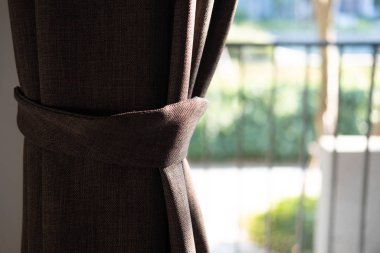 Kahverengi perde. Oda perdeleri için tutucu. Parça parça fotoğraf perdesi, iç mekan ayrıntıları, perde ayrıntıları. Seçici odak
