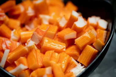 Dilimlenmiş surimi yengeç çubukları. Salata için deniz ürünleri ve malzeme. Sağlıklı beslenme.