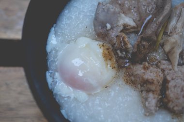 Haşlanmış yumurta, domuz ciğeri ve Tayland yemeğiyle birlikte pirinç lapası.