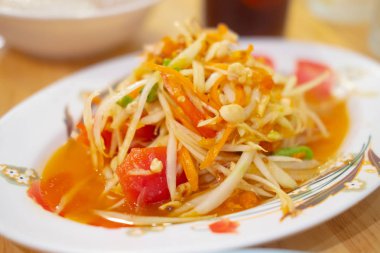 Beyaz tabakta Tayland papaya salatası. Sağlıklı Asya yemekleri konsepti