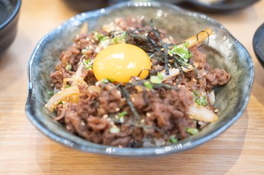 Soğan ve soya soslu Japon sığır eti kasesi üstüne yumurta koy. Adı da Gyudon.