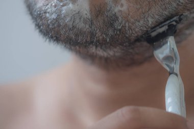 Adam sabah yüzünü banyoda tıraş ediyor. Kapat.