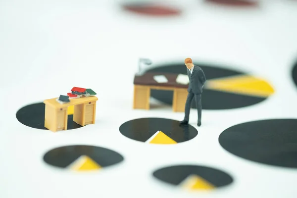 Miniature people businessman standing with table work desk on chart black and yellow circle for analysis business