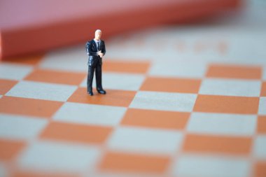 Miniature people: Businessman standing on the chess game, use as a business competition concept.