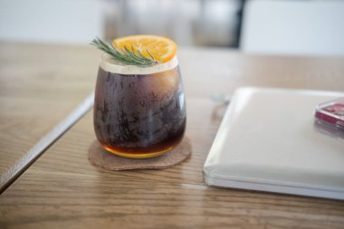 Portakal suyu espresso shot ve laptopla ahşap masada buzlu. Ofis masası