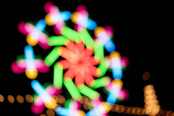 Blur colors light beam of fluorescent light colorful in festival temple fair night background, lighting beam in carnival colorful light shine show of thai temple fair festival color bokeh