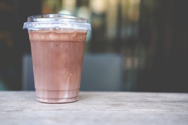 Plastik bardakta kapaklı buzlu kakao. Saman kullanımını azaltmak için içecek tasarımı, kahve fincanı kapağı içebilirsiniz.