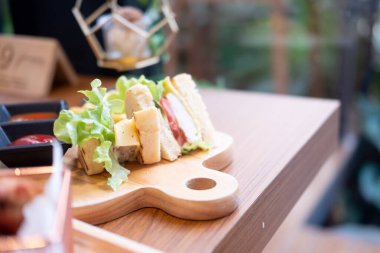 Salamlı ve ahşap tabakta domatesli sandviç peyniri.