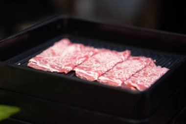 Shabu ve Sukiyaki Japon usulü siyah tepside taze et dilimi.