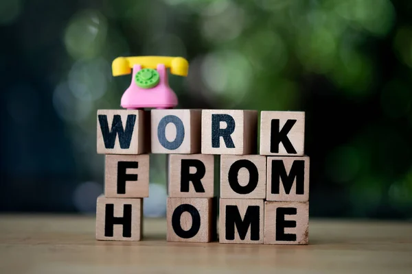 企业的缩写是Wfh作为在家工作的木制立方体和电话顶部 概念形象 — 图库照片