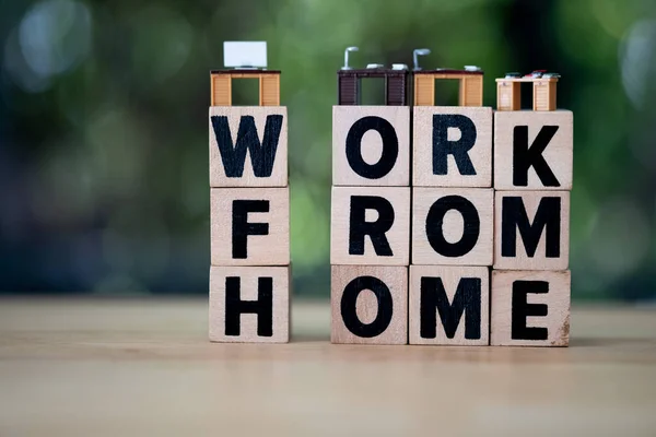 木制方块上的迷你写字台上写着 家里的活 这个字 Covid 19病毒爆发期间在家工作 — 图库照片
