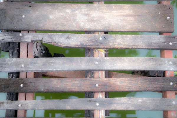 Top view of old planks wood pathway over of canal. Close up