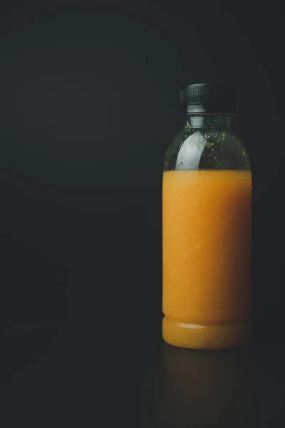 Eine Plastikflasche Mit Orangensaft Auf Schwarzem Hintergrund — Stockfoto