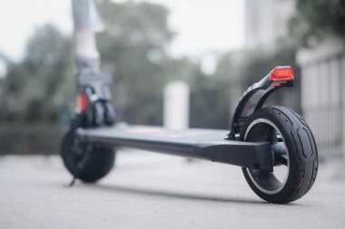 Kaldırıma park edilmiş e-scooter 'ın yakın görüntüsü. Modern elektrikli scooter 'la son moda şehir ulaşımı. Çevre dostu hareketlilik kavramı.