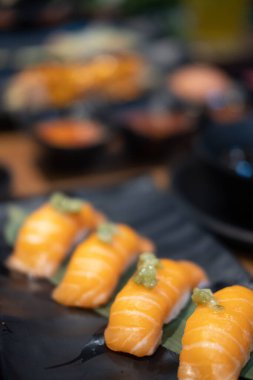 Siyah tabakta somon suşi nigiri. Seçici odak