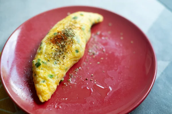 Kırmızı tabakta yumurtalı omlet. Lezzetli ve diyet yiyecekler. Kahvaltıda ya da öğle yemeğinde sağlıklı yemek.