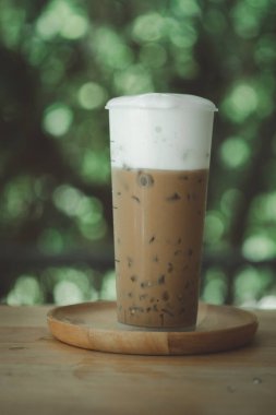 Süt köpüklü buzlu kahve uzun plastik bardakta.