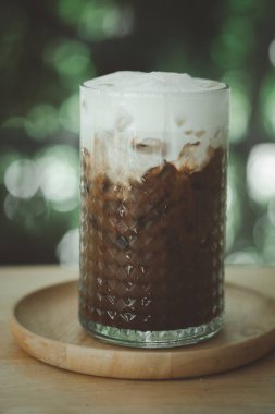 Ahşap masada sütlü buzlu Mocha.