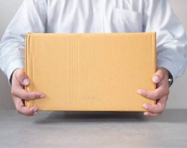 Karton kutu taşıyan teslimatçı. Hızlı ve ücretsiz teslimat. Çevrimiçi alışveriş ve ekspres teslimat.