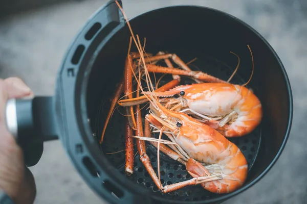 Nehir karidesi kızartma makinesinde pişiyor. Ev konseptinde kolay pişirme