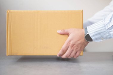 El ele tutuşan kahverengi kutu. Teslimat kavramı