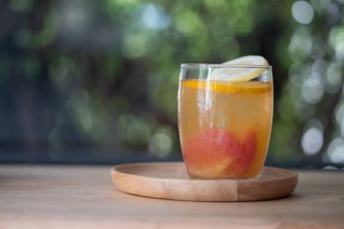 Tahta masada limon, limon, portakal ve greyfurt ile ev yapımı ferahlatıcı bir kokteyl.