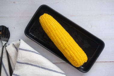 Taze mısır, tereyağı ve tuzla kaynatılmış siyah tepside.