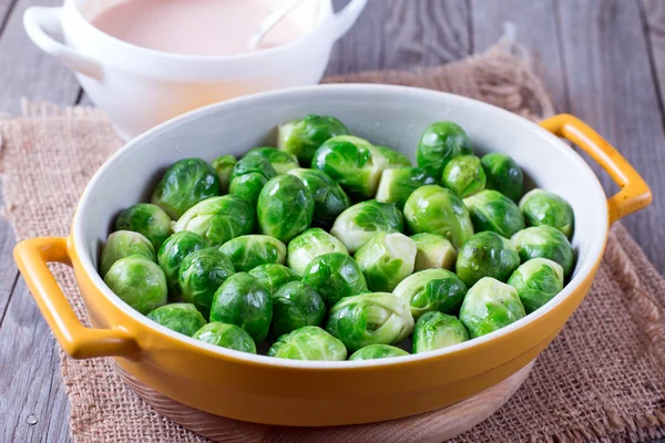 Ceramic bowl with brussels sprouts on wooden table — Stock Photo, Image
