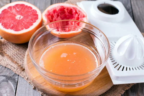 Exprimir el jugo de una naranja en un exprimidor manual — Foto de Stock