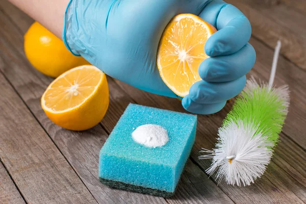 Limpiadores naturales ecológicos bicarbonato de sodio, limón y tela en la mesa de madera en la mano en la mesa de madera — Foto de Stock