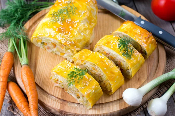 Strudel com repolho e cebolas em uma tábua de madeira — Fotografia de Stock