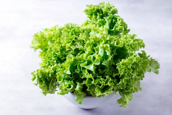 Салат листья в белой миске на столе — стоковое фото